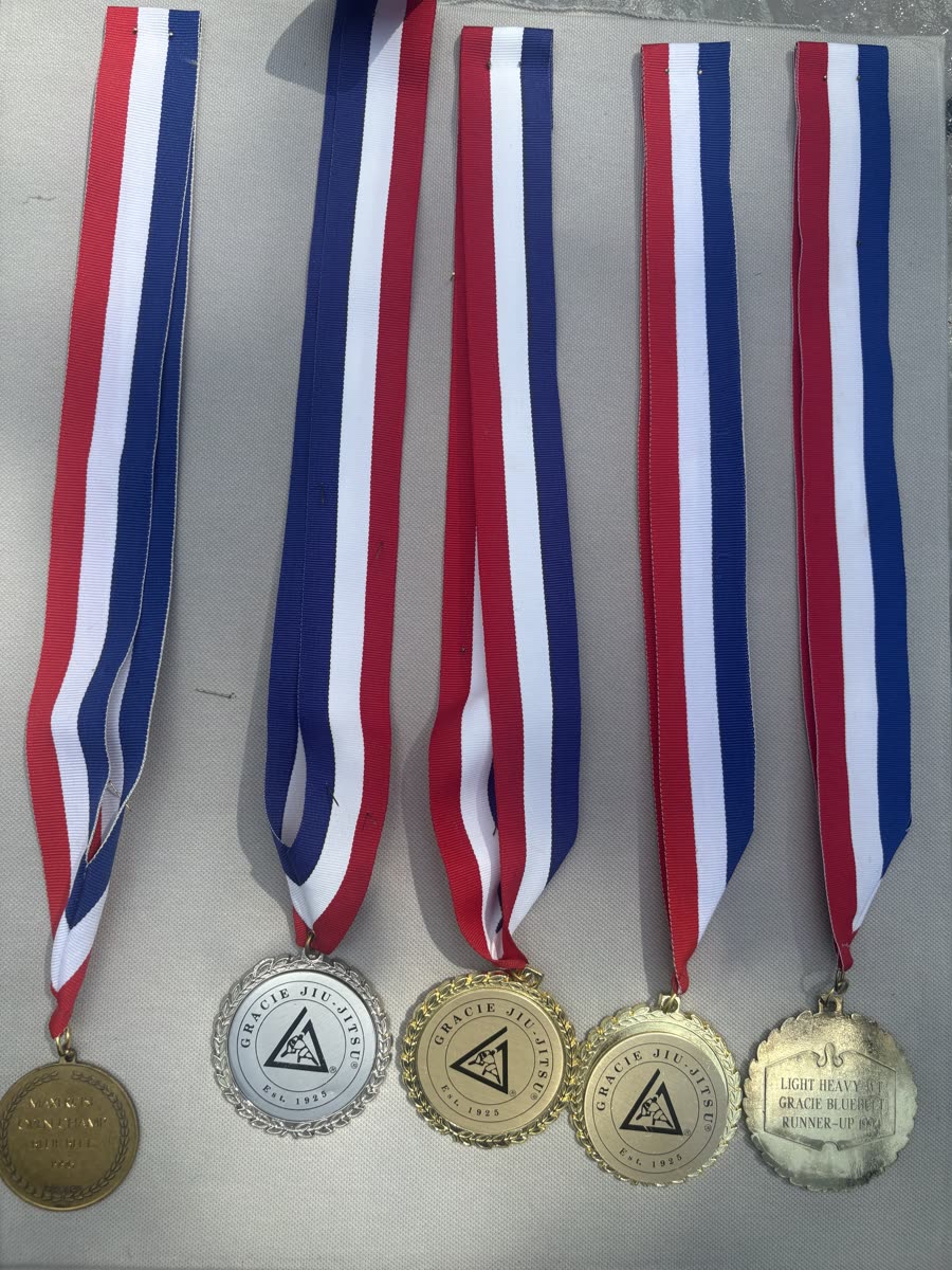 Five Gracie Jiu-Jitsu tournament medals on red, white and blue ribbons